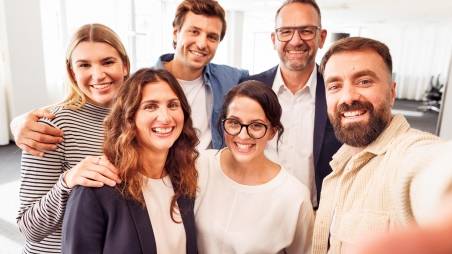 Selfie: 6 Kaufland-Mitarbeiter posieren zum Gruppenbild im Büro.